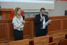 Kobieta i mężczyzna z mikrofonami otwierają konferencję w auli