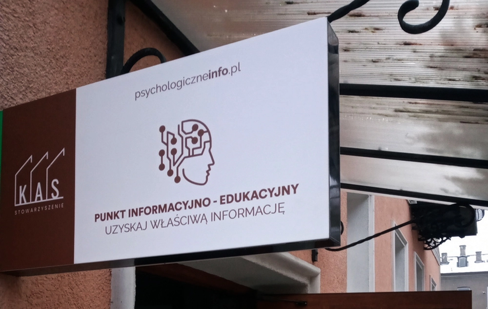 Szyld Punktu Informacyjno-Edukacyjnego psychologiczneinfo.pl nad wejściem do lokalu
